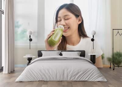 young woman drinking detox drink made by vegetable and fruit mixed. Wall mural