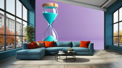 An hourglass with blue sand on a purple background. Wall mural