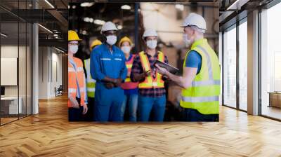 The manager or leader team is assignmenting a job for team of technicians, supervisor, foreman and engineers In the morning meeting before work In which everyone wear masks to prevent the coronavirus Wall mural