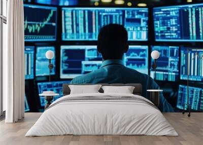 A financial analyst reviewing stock market data on multiple computer screens in a busy trading room Wall mural