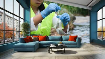 Female environmentalist hands in glove collects water samples from a river to explore and testing for infections. Water and ecology concept Wall mural