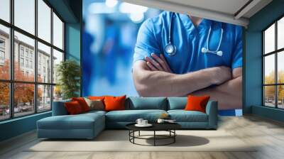 Closeup of a healthcare professional in scrubs with arms crossed and a stethoscope around their neck,Doctor against a blurred background of medical staff in a hospital,clinic setting,Healthcare. Wall mural