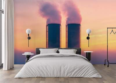 Two tall industrial towers emit steam against a colorful sky, partially shrouded in fog, creating a dramatic and atmospheric scene at sunrise. Wall mural