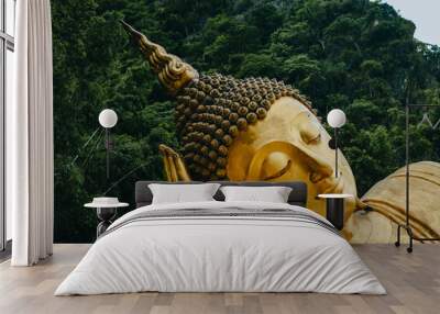 Close up of Reclining Buddha gold statue face with mountain background inThailand. Wall mural