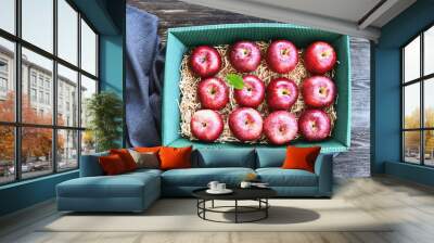 A lot of fresh Royal Red Gala apples and green leaf in paper box on wooden background. Wall mural