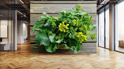 Fresh Rapeseed leaves and flowers in basket for cooking like a  broccoli and green vegetable. Wall mural