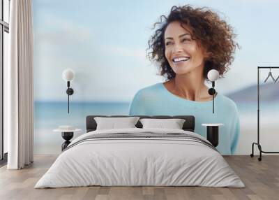 Joyful woman enjoying sunny day at beach. Embracing wellness and leisure. Wall mural