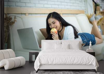 Young beautiful woman using a laptop computer at home. Wall mural