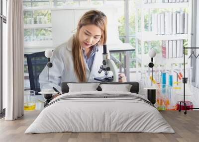 asian scientist working in laboratory with microscope Wall mural