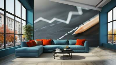 A close-up view of a pencil resting on a blackboard with a rising graph, symbolizing growth and financial progress. Wall mural