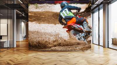 Close-up part of mountain bikes race in dirt track with flying debris during an acceleration in sunshine day time. Concept of focus between an accelerate in action sport Wall mural