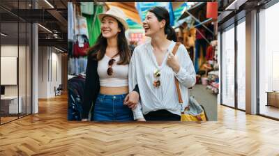 group of asian korean women shopping and walking in taipei taiwan. two girls travelers having fun in city while visiting in local traditional market. tourists friends sharing happy moments together Wall mural