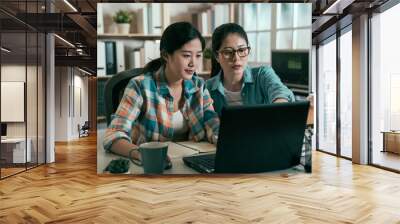 vintage two designers working in company office using laptop computer. group of asian female partner Wall mural