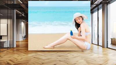 woman travel in beach and holding sunscreen bottle Wall mural