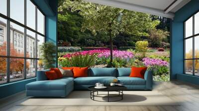 Lush garden blooming in the springtime with tulips, flowerbeds and lawns Wall mural