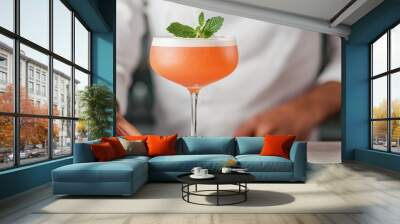 A refreshing cocktail garnished with mint leaves, served in a stylish glass on a bar counter. Perfect for summer evenings and social gatherings. Wall mural