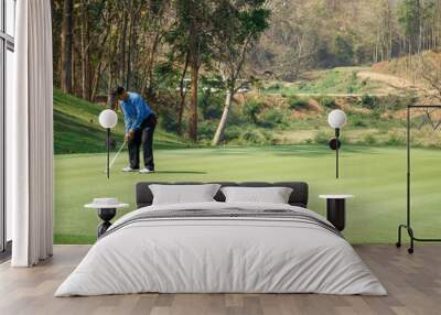 Man playing golf on a golf course. Wall mural