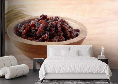 Raisin in bowl on wooden background. Wall mural