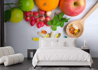 Multivitamin supplements from fruit on white wooden background Wall mural