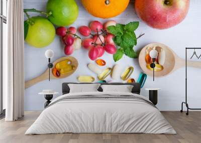 Multivitamin supplements from fruit on white wooden background Wall mural