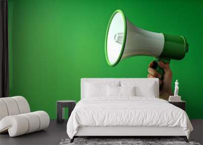 A hand holding a megaphone against a green background, copy space Wall mural