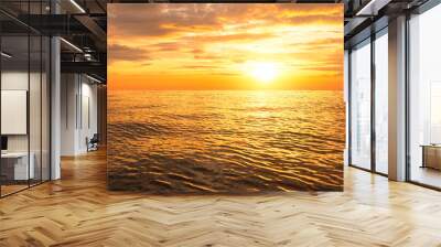 Beautiful golden sunrise sky background over sea with orange clouds and yellow sunlight on sea surface in the morning Wall mural