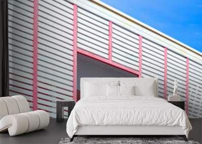 Modern house in minimal style with white wooden battens and pink balustrade on terrace against blue sky background in vertical frame Wall mural