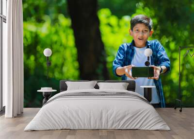 childhood, technology and people concept - indian cute school boy showing smartphone with blank screen Wall mural