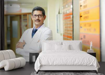 Confident Indian male doctor standing at hospital. Wall mural