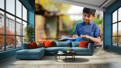 Cute indian child studying at home Wall mural