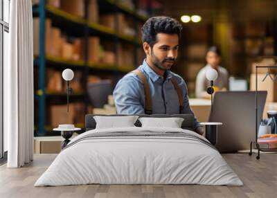 indian man using laptop at warehouse Wall mural