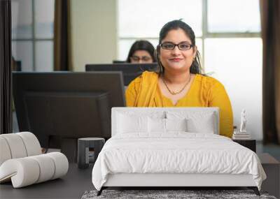 Indian woman working on computer at office. Wall mural