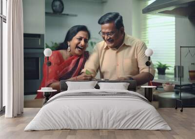 Senior indian couple cooking together at kitchen Wall mural