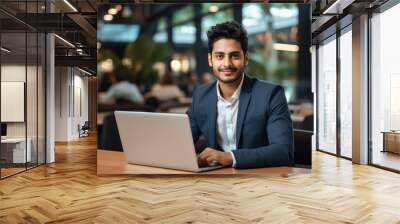 Young businessman or corporate employee using laptop at office Wall mural