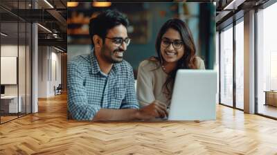 Young indian man and woman who corporate employee using laptop and discussing at office Wall mural