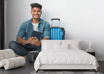 young indian man sitting with travelling bag on white background Wall mural