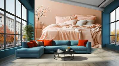 A cozy bedroom with a bed dressed in soft peach fuzz color bedding. Modern trendy tone hue shade Wall mural