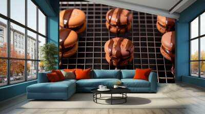 Appetizing freshly made desserts macarons covered with melted chocolate in rows on metal mesh Wall mural