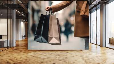 Close up of womans hand holding shopping bags while walking on the street. Wall mural