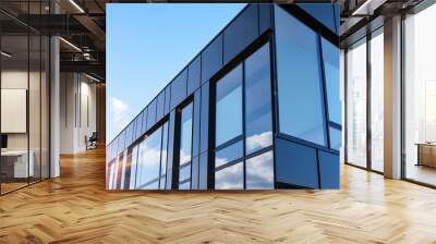 Graphite facade and large windows on a fragment of an office building against a blue sky. Modern aluminum cladding facade with windows. Wall mural