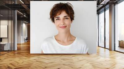 Head shot of beautiful caucasian woman with short haircut, smiling and looking confident, standing in t-shirt on white background Wall mural