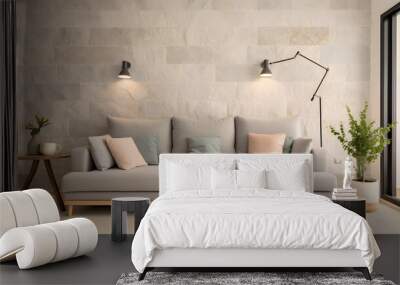 Light grey living room sofa decorated with pillows, a lamp, a bag and a plant in front of a natural stone wall Wall mural