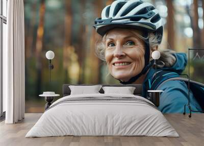 Mature woman wearing helmet before a bike trip in the woods Wall mural