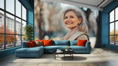 Portrait of cheerful happy retired woman walk smile spring good mood touch hair weekend wear beige coat enjoy outdoors outside park street Wall mural