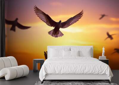 Silhouette pigeon return coming to hands in air vibrant sunlight sunset sunrise background. Freedom making merit concept. Nature animal people hope pray holy faith. International Day of Peace theme. Wall mural