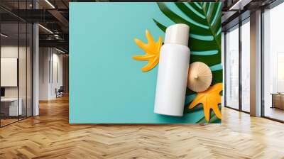 Sunscreen spray bottle. Bottle with sun protection cream and sea shells with tropical green leaf on color background, top view Wall mural