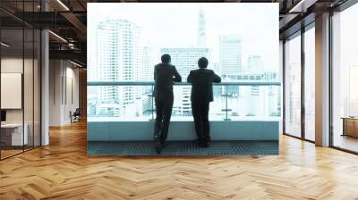 Two businessman talking on a roof and looking at city Wall mural