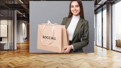 beautiful young brunette woman holding a bag with social media smiling  Wall mural