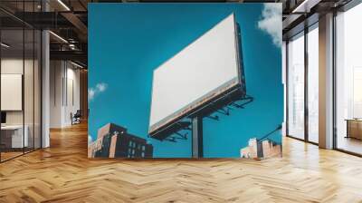 A blank billboard stands against a blue sky, highlighting urban advertising space. Wall mural