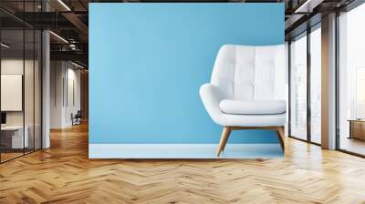 Modern white velour chair on wooden legs isolated on blue background copy space. AI generated image Wall mural